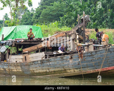 Holz- Frachtschiff entladen Kies und Steine auf einen Lkw durch Pumpen mit Wasser in einem Dorf an der tanintharyi Fluss in der tanintharyi Regi Stockfoto