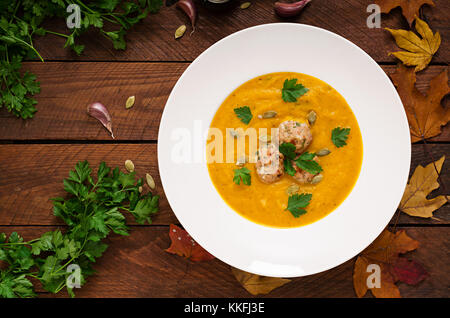 Leckere Kürbiscremesuppe mit fleischbällchen der Türkei Hackfleisch in eine Schüssel auf einem Holztisch. Blick von oben. Flach. top anzeigen. thanksgivi Stockfoto