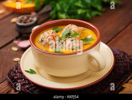 Leckere Kürbiscremesuppe mit fleischbällchen der Türkei Hackfleisch in eine Schüssel auf einem Holztisch. Blick von oben. Tag Thanksgiving. Stockfoto