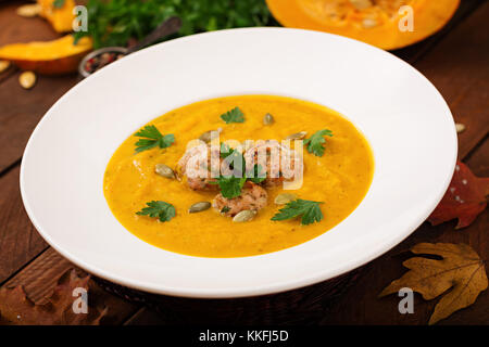 Leckere Kürbiscremesuppe mit fleischbällchen der Türkei Hackfleisch in eine Schüssel auf einem Holztisch. Blick von oben. Tag Thanksgiving. Stockfoto