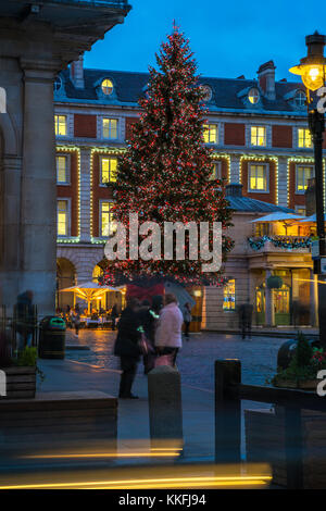 LONDON - 30. NOVEMBER 2017: Großer, geschmückter Weihnachtsbaum im Londoner Covent Garden mit festlichen Lichtern zieht Tausende von Londonern an Stockfoto