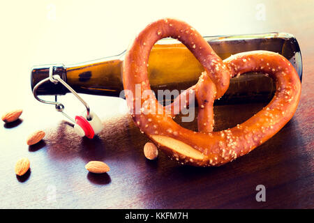 Flasche Bier und frisch gebackene Brezel. selektive Fokus in der Mitte der Brezel Stockfoto