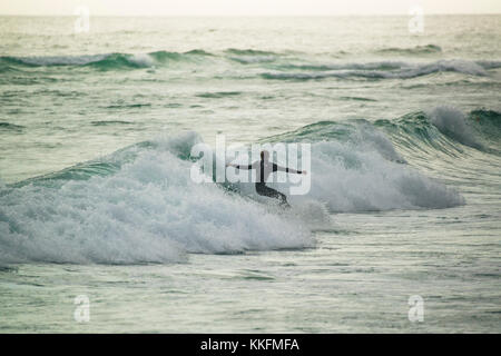 Surfer bei Sonnenuntergang, Big Bay, Kapstadt, Südafrika Stockfoto