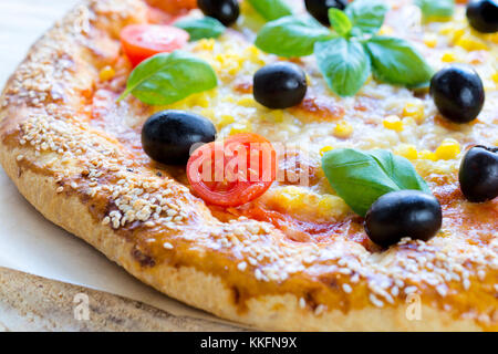 Frisch gebackene vegetarische Pizza. Selektive konzentrieren sich auf die Scheibe Tomate. Stockfoto