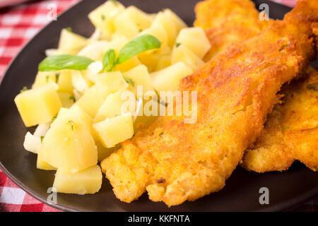 Gebratener Fisch und Kartoffelsalat in der Platte Stockfoto