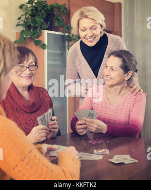 Fröhlich lächelnd weibliche Rentner Karten zu Hause spielen Stockfoto