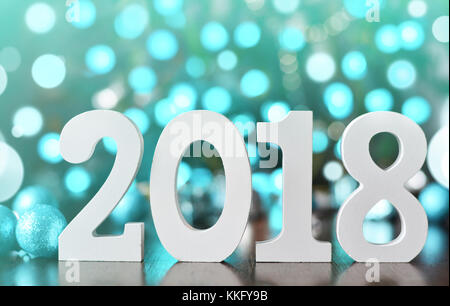 Holz- Zahlen bilden die Zahl 2018, für das neue Jahr 2018 auf einer Glitter verschwommenen Hintergrund Stockfoto
