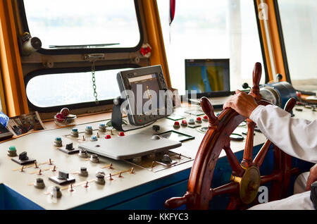 Schließen Blick in's Captain Kabinen, Navigationsgeräte und des Kapitäns Hand am Ruder während der Kreuzfahrt Stockfoto