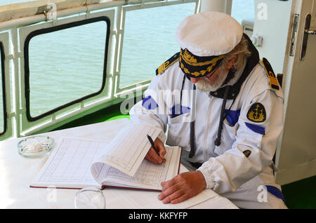 Alten erfahrenen Kapitän füllt das Logbuch nach dem Schiff Navigation Stockfoto