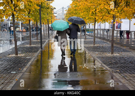 Ein Mann und eine Frau sind zu Fuß entlang der Krim-Damm im Herbst regen im Zentrum von Moskau, Russland Stockfoto