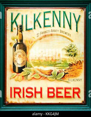 Alte Zinn Teller Metall antik Werbung für Kilkenny Irish Beer vor einer Bar in Tralee, County Kerry, West-Irland. Stockfoto