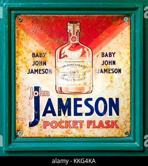 Alte Zinn Teller Metall antik Werbung für Jameson Irish Whiskey vor einer Bar in Tralee, County Kerry, West Irland. Stockfoto