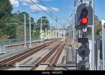 Eisenbahnschienen, die Stadt als von einem Bahnsteig gesehen. Stockfoto