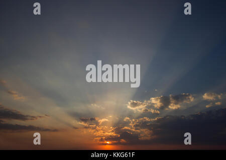 Horizontale Foto eines wunderschönen Sonnenuntergang Himmel reich in den Wolken und die Farbe mit der Sonne in der Mitte des Bildes Stockfoto
