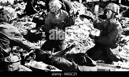 Verwundeter am Strand von Eniwetok ist ein eindrucksvolles Foto aus dem Zweiten Weltkrieg, das die Folgen der Schlacht von Eniwetok feststellt. Das Bild spiegelt die Auswirkungen des Krieges und seine menschlichen Kosten auf die Soldaten während des Pazifikfeldzugs wider. Stockfoto