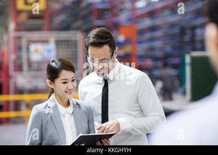 Kaufmann und Kauffrau im Gespräch in der Fabrik Stockfoto