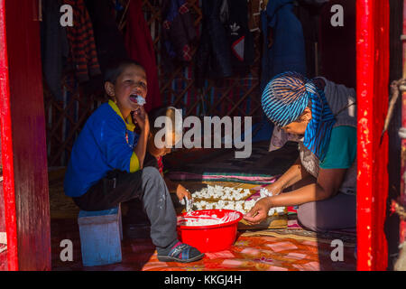 Song kul, Kirgisistan - 11. August: Frau und zwei Kinder, kurut, traditionelle Käse Kugeln in einer Jurte. august 2016 Stockfoto