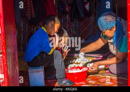 Song kul, Kirgisistan - 11. August: Frau und zwei Kinder, kurut, traditionelle Käse Kugeln in einer Jurte. august 2016 Stockfoto