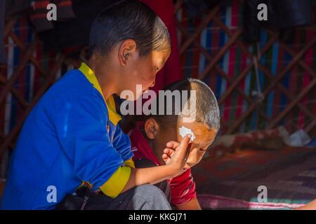 Song kul, Kirgisistan - 11. August: zwei Kinder Herstellung und Verkostung kurut, traditionelle Käse Kugeln in einer Jurte. august 2016 Stockfoto