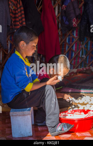 Song kul, Kirgisistan - 11. August: zwei Kinder Herstellung und Verkostung kurut, traditionelle Käse Kugeln in einer Jurte. august 2016 Stockfoto