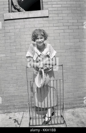 Dieses historische Foto fängt einen Moment aus dem berühmten Scopes Trial von 1925 in Dayton, Tennessee, ein. Das Bild zeigt eine nicht identifizierte Frau, die auf einem Regal steht und sich lehnt, und bietet einen Einblick in das tägliche Leben und die soziale Atmosphäre rund um dieses bedeutende juristische Ereignis. Stockfoto
