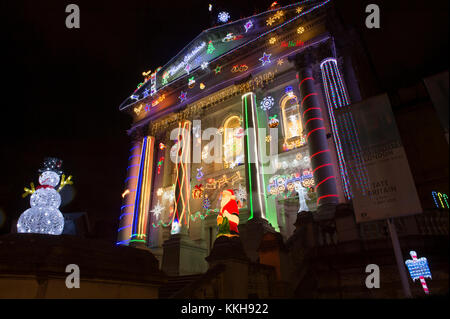 Tate Britain, London, UK. 1. Dezember, 2017. 06.30. Alan Kane hat eine aufregende neue Arbeit für die kultigen Fassade des Tate Britain erarbeitet die Weihnachtszeit zu markieren. Home für Weihnachten verwandelt sich die neo-klassische Fassade der Galerie in eine leuchtende Anzeige von handelsüblichen Dekorationen. Ein show-stopping Anordnung der LED-Weihnachtsmänner, Rentiere, Schneemänner und Weihnachtsbäume, zusammen mit "Frohe Weihnachten" und "Santa Stop Hier' Zeichen schmücken die Viktorianischen porticoed Eingang. Credit: Malcolm Park/Alamy Leben Nachrichten. Stockfoto