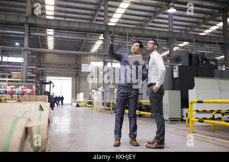 Unternehmer und Ingenieur im Gespräch in der Fabrik Stockfoto