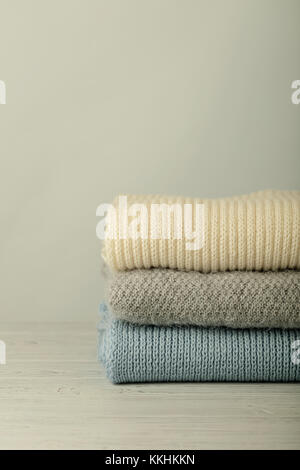 Stapel aus Gewirken Kleider (Pullover, Schals, Pullover) blauen, weißen und grauen Farben. Selektive konzentrieren. Stockfoto