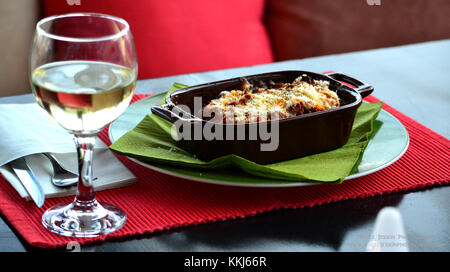 Eine griechische Lasagne und ein Wein in der Sonne Stockfoto