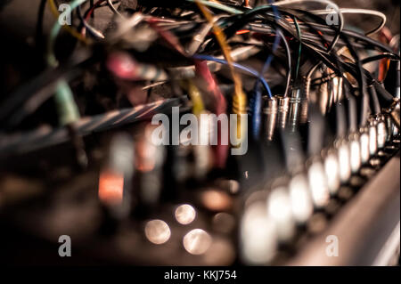 Viele Audiokabel an einen Studio-Mixer angeschlossen, selektiver Fokus, Nahaufnahme Stockfoto