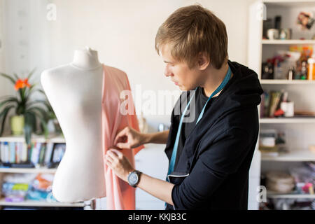 Fashion Designer mit Dummy, Kleid im Studio Stockfoto