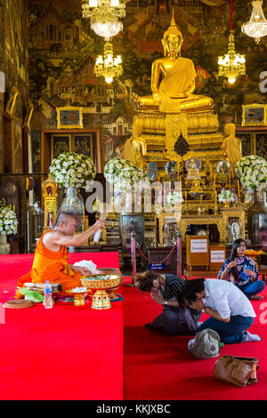 Bangkok, Thailand. Ein Paar erhält ein Segen von einem buddhistischen Mönch in der ubosot des Wat Arun Tempel. Stockfoto