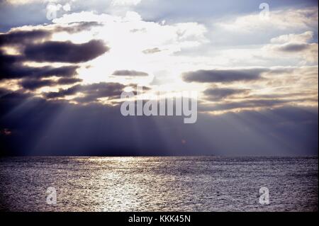 Licht Strömen vom Himmel wie die Sonne über Gewitterwolken über dem Lake Michigan an der Küste von Montrose Hafen in Chicago, Illinois, USA bricht. Stockfoto