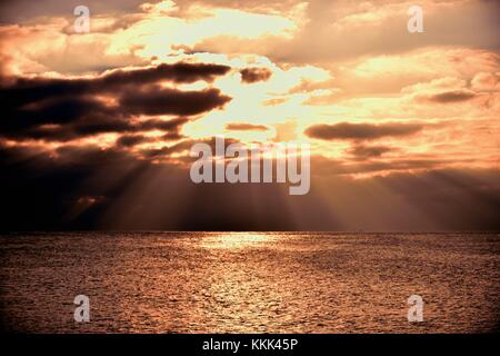 Licht Strömen vom Himmel wie die Sonne über Gewitterwolken über dem Lake Michigan an der Küste von Montrose Hafen in Chicago, Illinois, USA bricht. Stockfoto