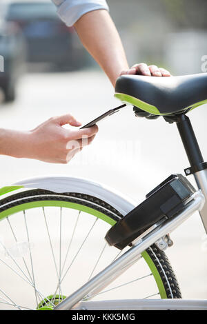 Die jungen Chinesen das Scannen eines QR-Code einen Anteil Bike zu entsperren. Stockfoto