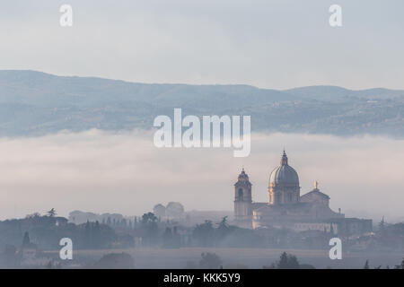 Schönen Blick auf Santa Maria degli Angeli (Assisi) päpstliche Kirche in der Mitte des Nebels in der Morgendämmerung Stockfoto