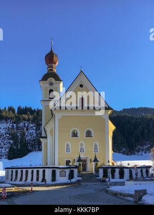 Kleine Kirche in Going am Wilden Kaiser auf ein Winter am Nachmittag vor einem blauen Himmel Stockfoto