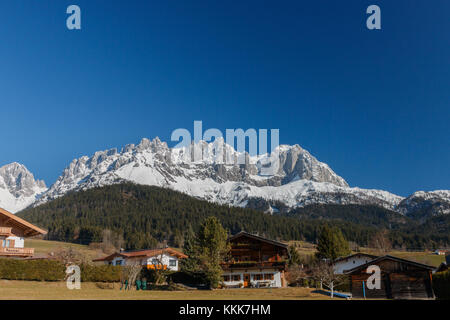 Wunderschöne Gebirgskette (Kaiserberge) mit traditionellen Häusern vor dem Wilden Kaiser in Tirol, Österreich Stockfoto