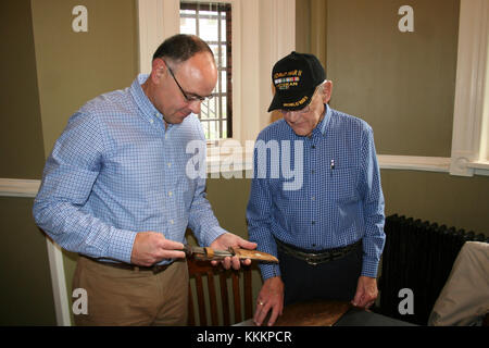 Weltkrieg II Army veteran Charlie Brown in Olean, New York beschreibt seine Erfahrungen in Europa als Teil der 258th Field Artillery Battalion mit Courtney Verbrennungen, Direktor des Museums an der New York State Military Museum in Saratoga Springs, New York, 20. November 2017. Braun met mit modernen Soldaten der Einheit seiner Sammlung von Artefakten und Informationen über das Bataillon WWII combat Service zu überprüfen. ) Usa Nationalgarde Foto von Oberst Richard Goldenberg.) Stockfoto