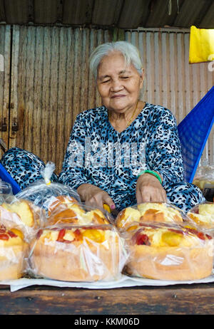 Hai Duong, Vietnam - Apr 30, 2015. ältere Frau verkaufen Reis Kuchen in Gold Markt in Thanh Ha, Hai Duong, Vietnam. Dies ist der älteste Börse in der Stockfoto