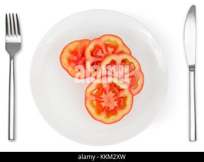 Scheiben Tomaten auf weißen Teller mit Messer und Gabel auf weißem Hintergrund. gesundes Essen. Stockfoto