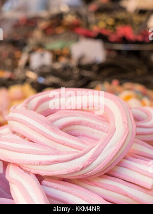 Geflecht der rosafarbenen und weißen Marshmallow im Vordergrund. Vielfalt von bunten Bonbons auf dem Hintergrund Stockfoto