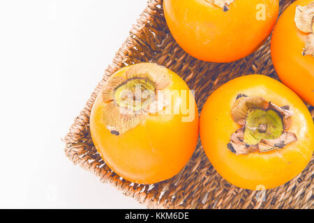 Frische natürliche kaki Obst im Korb auf weißem Hintergrund Stockfoto