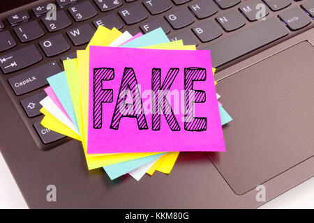 Schreiben von Fake News-Text aus der Nähe des Büros auf der Tastatur des Laptops. Geschäftskonzept für Fake News Workshop auf schwarzem Hintergrund mit s Stockfoto