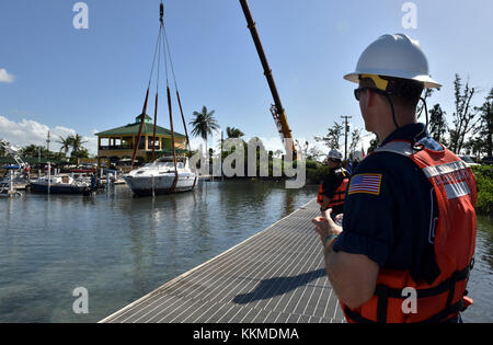 Coast Guard Petty Officer 3rd Class Ian Fenwick beobachtet, wie der 38-Fuß-Freizeit Schiff, Spuk'n mich, an einem Jachthafen in Ponce, Puerto Rico, an November 22, 2017 geborgen ist. Die Maria Emergency Support Funktion 10 Puerto Rico Unified Befehl, der aus der Abteilung der natürlichen und ökologischen Ressourcen ist, der U.S. Coast Guard, in Verbindung mit dem Puerto Rico Environmental Quality Control Board, Umweltschutz und der USA und Fish & Wildlife Service, arbeitet, Schiffe, die beschädigt wurden und durch den Hurrikan Maria vertriebenen zu entfernen. U.S. Coast Guard Foto von KLEINLICHEN von Stockfoto