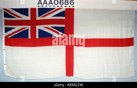 Die White Ensign ist die Marineflagge des Vereinigten Königreichs, die traditionell von Schiffen und Einrichtungen der Royal Navy geflogen wird. Er verfügt über einen Union Jack in der oberen linken Ecke und ein weites Weißfeld. Stockfoto