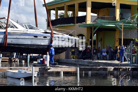 Einheimische sammeln an einem Jachthafen in Ponce, Puerto Rico, an November 22, 2017, und beobachten Sie, wie Bergung Personal der 38-Fuß-Freizeit Schiff Spook'n mir Maria ESF-10 PR Unified Befehl heben, bestehend aus der Abteilung der natürlichen und ökologischen Ressourcen, der U.S. Coast Guard, in Verbindung mit dem Puerto Rico Environmental Quality Control Board, Umweltschutz und der USA und Fish & Wildlife Service, reagiert auf Schiffe beschädigt werden, Vertriebene, in Wasser getaucht oder versunkenen. U.S. Coast Guard Foto von Petty Officer 2. Klasse Ali Flockerzi. Stockfoto