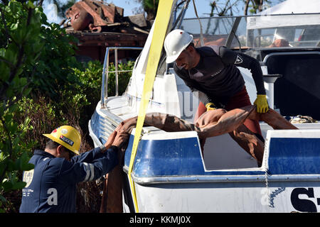 Lokale Bergung und Tauchen Team Personal Hebebänder einstellen, um die 38-Fuß-Freizeit Schiff Spook'n mich an November 22, 2017 in Ponce, Puerto Rico, nachdem es an Land gespült, als Hurrikan Maria die Insel getroffen. Die Maria ESF-10 PR Unified Command, bestehend aus der Abteilung der natürlichen und ökologischen Ressourcen, der U.S. Coast Guard, in Verbindung mit dem Puerto Rico Environmental Quality Control Board, Umweltschutz und der USA und Fish & Wildlife Service, reagiert auf Schiffe beschädigt werden, Vertriebene, in Wasser getaucht oder versunkenen. U.S. Coast Guard Foto von Petty Officer Stockfoto