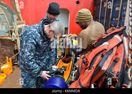 ATLANTISCHER OZEAN (Nov 22, 2017) Brandsteuerungstechniker 1. Klasse Alvin Miller, rechts, Leiter Brandsteuerungstechniker Brian Vinella, oben links, Und Chief Electronics Technician (Submarine Navigation) Casey Smith, unten links, alle zugeordnet zu Unmanned Undersea Vehicle Squadron 1 (UUVRON 1), führen Wartungsarbeiten an einem Bluefin-12D, einem unbemannten Unterwasser-Fahrzeug, an Bord des norwegischen Bauunterstützungsschiffs Skandi Patagonia. Undersea Rescue Command, die einzige U-Boot-Rettungseinheit der US Navy, und Mitglieder von UUVRON 1 werden mobilisiert, um die Suche der argentinischen Regierung zu unterstützen Stockfoto