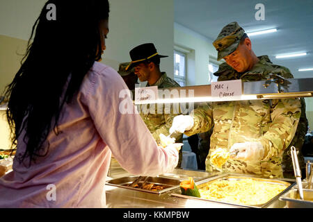 Oberstleutnant Coleman Johnson, Kommandant der 497Th bekämpfen Sustainment Support Battalion, Makkaroni und Käse zu Soldaten in Powidz, Polen während ein Thanksgiving Essen Feier, Nov. 23, 2017 bereitgestellt. Soldaten in Powidz unterstützen Atlantic lösen, eine in den USA bemühen sich NATO-Verpflichtungen durch US-drehen-basierte Einheiten in der gesamten Europäischen theater Aggression gegen NATO-Verbündeten in Europa abzuhalten, zu erfüllen. (U.S. Armee Foto von Sgt. Gregory T. Sommer/22 Mobile Public Affairs Abteilung) Stockfoto